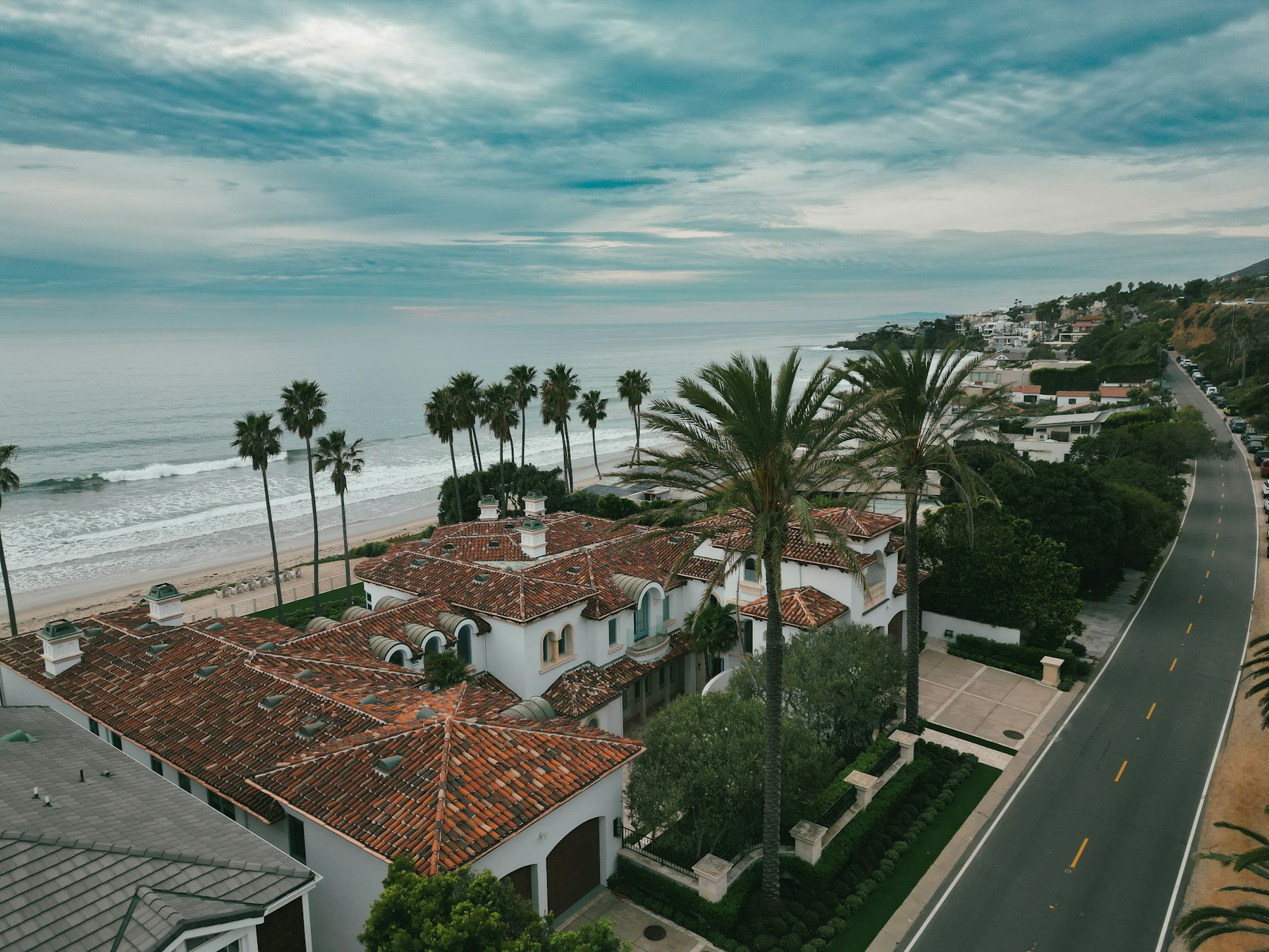 Drone view of a beachfront estate and shoreline in Malibu, California