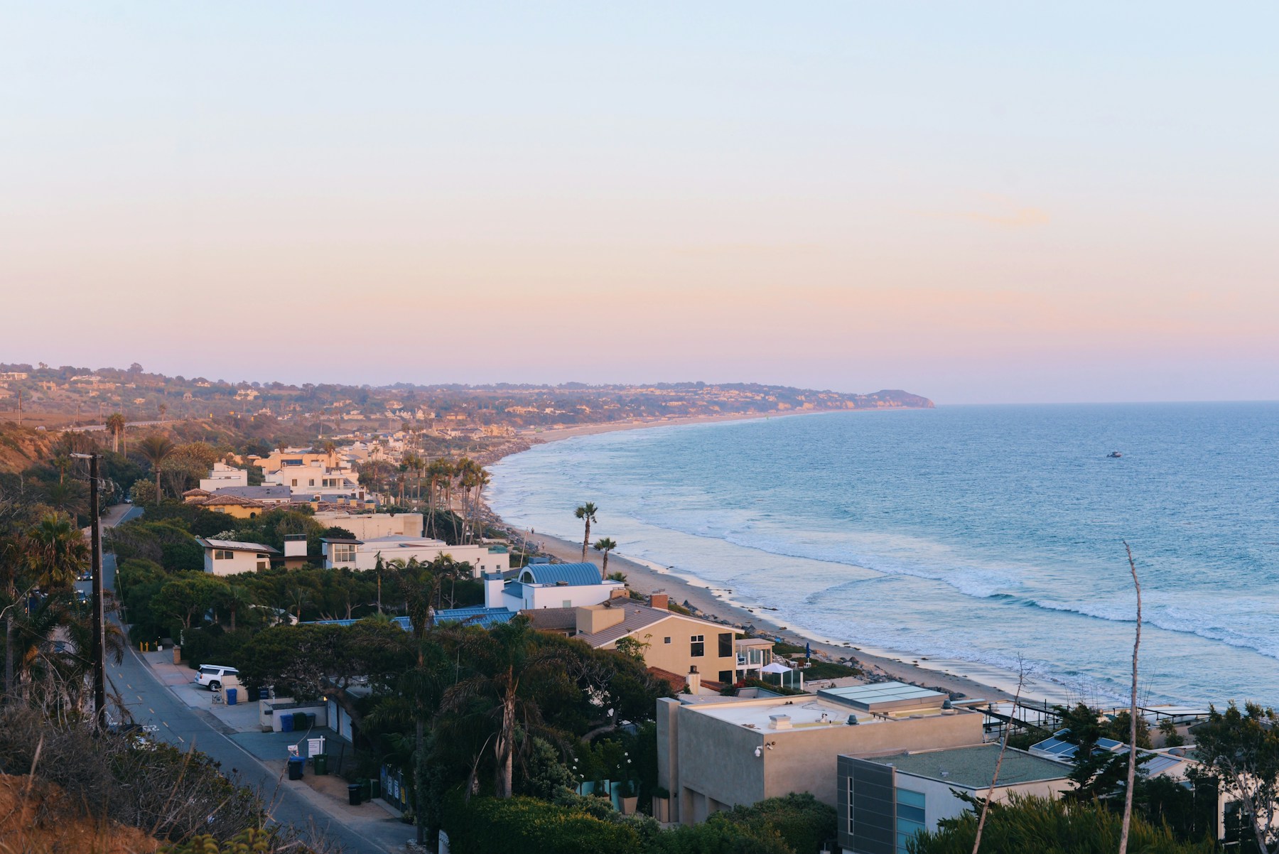 Elevated view of Malibu homes lining the Pacific coast at sunset