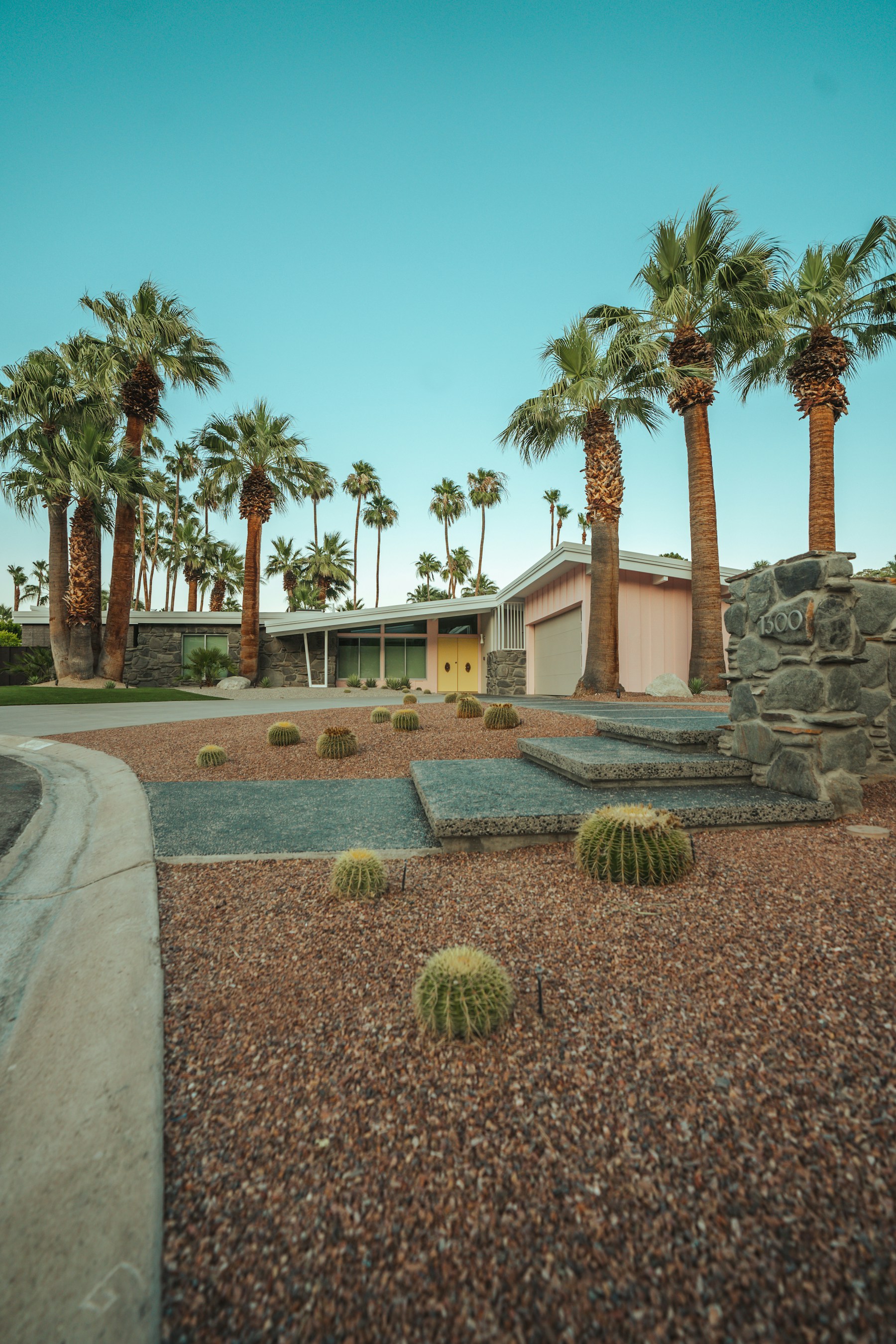 Authentic Palm Springs midcentury residence framed by palms and desert landscaping